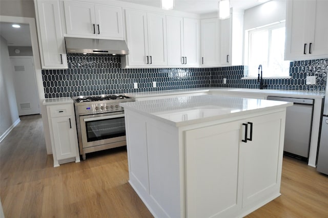 kitchen featuring stainless steel appliances, a center island, extractor fan, and white cabinets