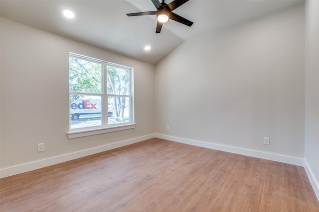 unfurnished room with ceiling fan, vaulted ceiling, and light wood-type flooring