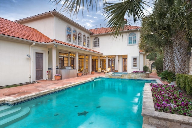 view of pool with a patio area, exterior kitchen, and an in ground hot tub