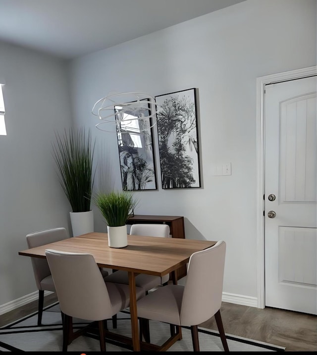 dining area with baseboards and wood finished floors