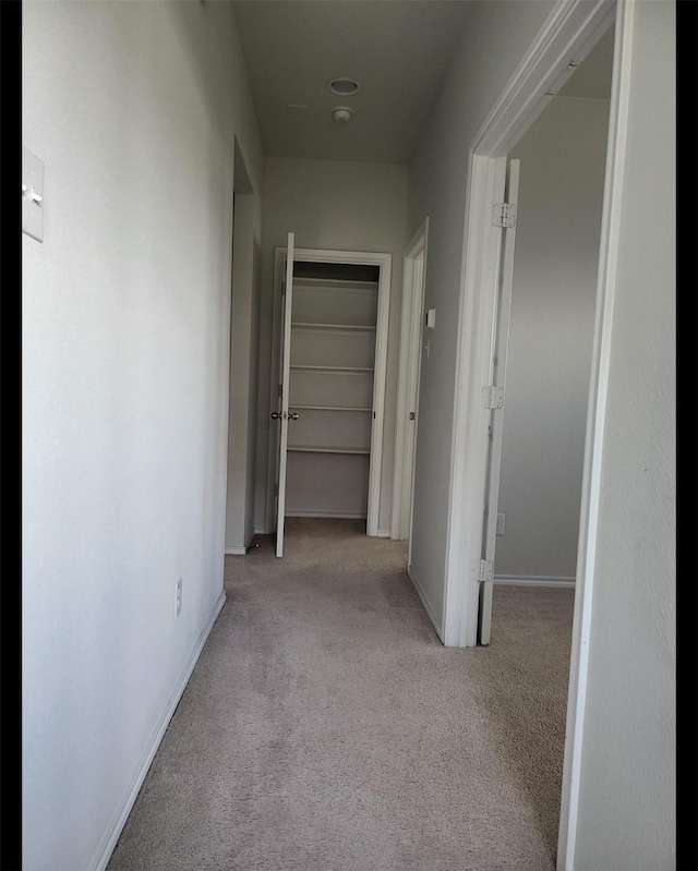 hallway with carpet floors and baseboards