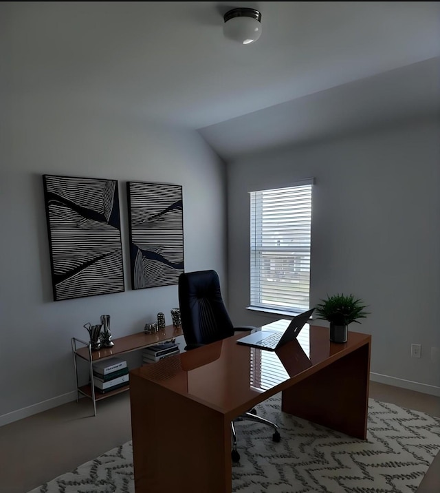 office area featuring vaulted ceiling and baseboards