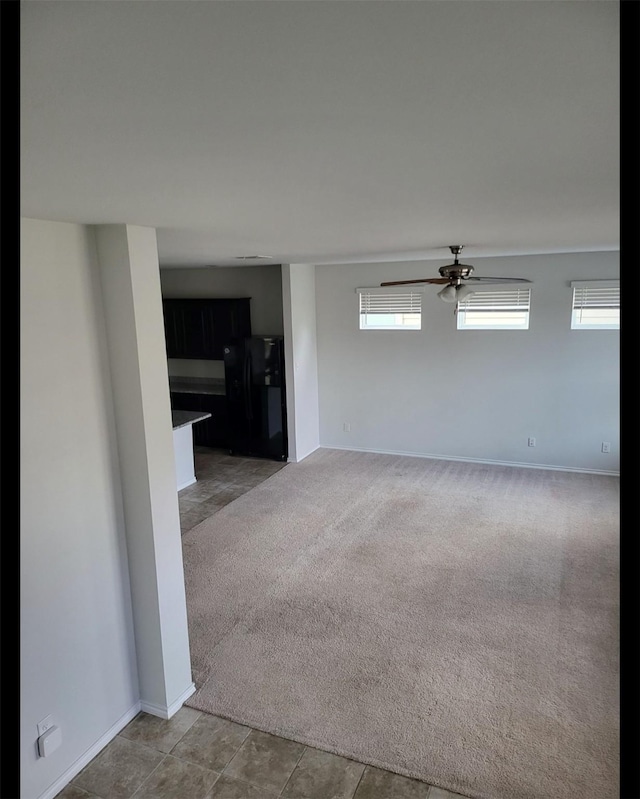 unfurnished room with carpet, baseboards, and ceiling fan