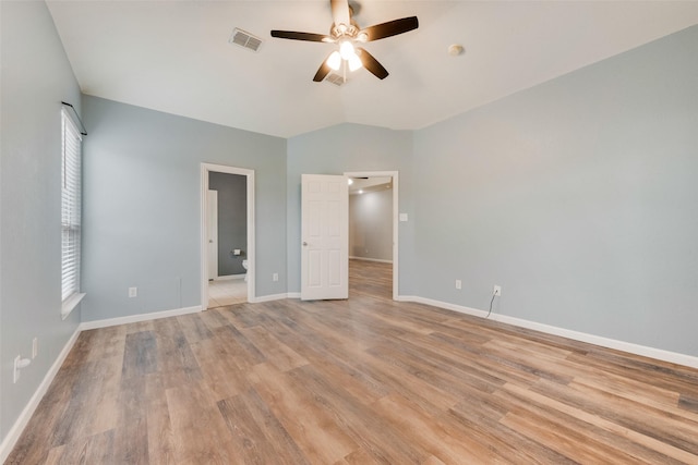 unfurnished bedroom with ceiling fan, vaulted ceiling, and light wood-type flooring