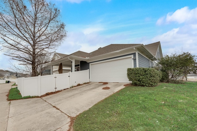 view of side of home featuring a garage and a lawn