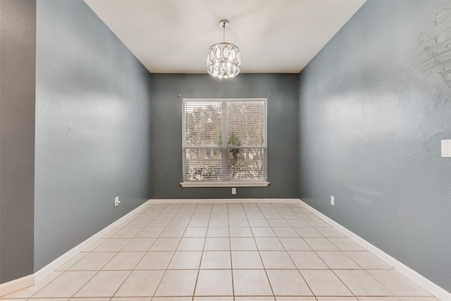 tiled empty room with a chandelier