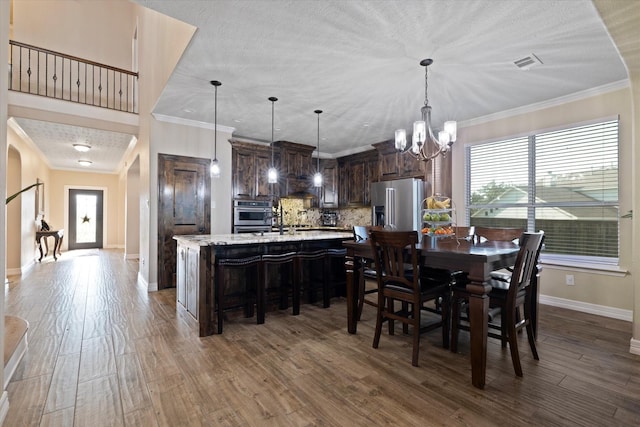 dining area featuring crown molding, hardwood / wood-style flooring, and a wealth of natural light