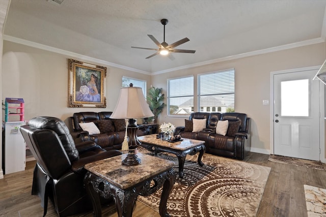 living room featuring hardwood / wood-style flooring, ceiling fan, ornamental molding, and a textured ceiling