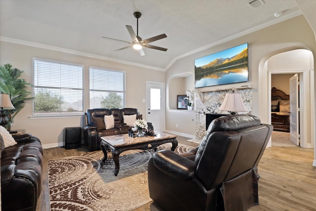 living room with crown molding, a fireplace, and light hardwood / wood-style flooring