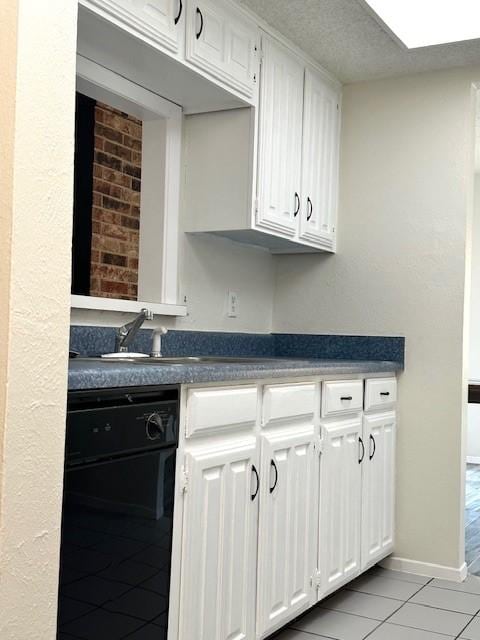 kitchen with light tile patterned flooring, dishwasher, sink, and white cabinets