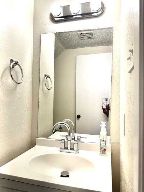 bathroom with vanity and vaulted ceiling