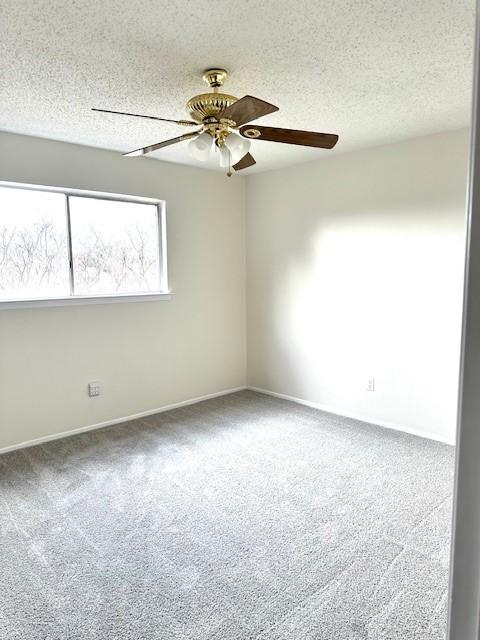 unfurnished room with ceiling fan, carpet flooring, and a textured ceiling