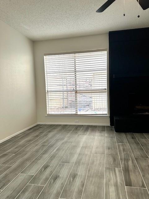 spare room featuring ceiling fan, wood-type flooring, and a textured ceiling