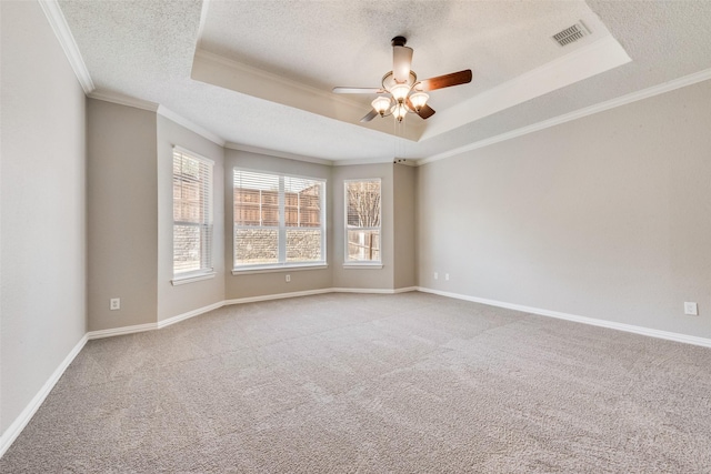 unfurnished room with ceiling fan, ornamental molding, a textured ceiling, light colored carpet, and a raised ceiling