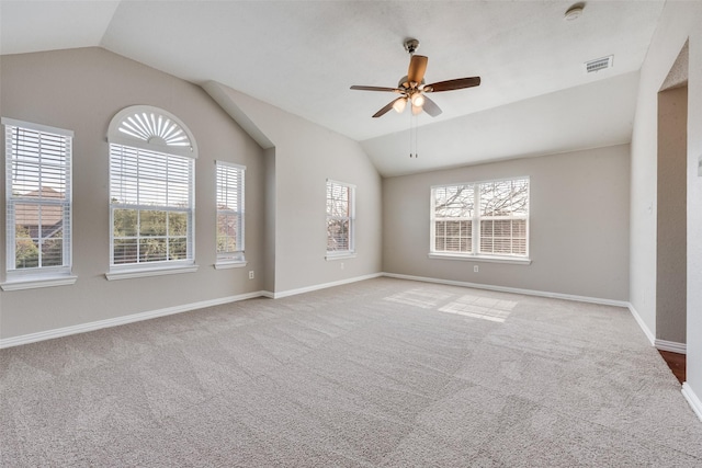 carpeted spare room with ceiling fan and vaulted ceiling