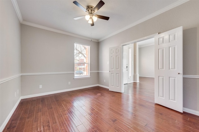 empty room with crown molding, dark wood-type flooring, and ceiling fan