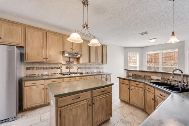 kitchen with tasteful backsplash, sink, hanging light fixtures, a center island, and stainless steel appliances