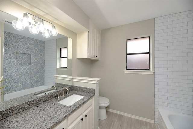 bathroom with vanity, a bathing tub, and toilet