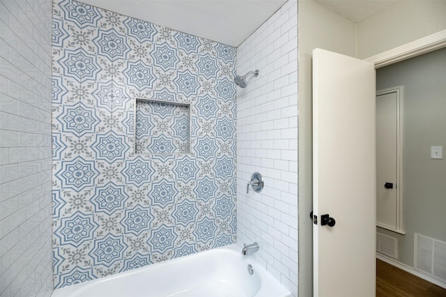 bathroom featuring tiled shower / bath