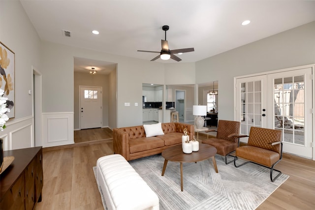 living room featuring french doors, ceiling fan, and light hardwood / wood-style floors