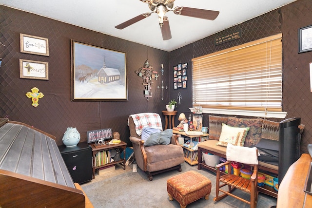 living area featuring carpet and ceiling fan