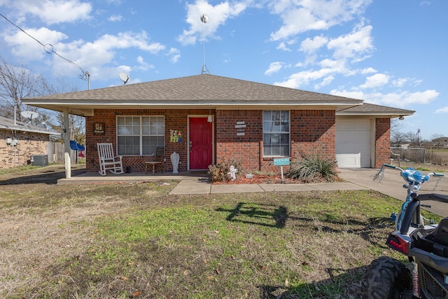 view of front of house with a garage, brick siding, roof with shingles, and a front yard