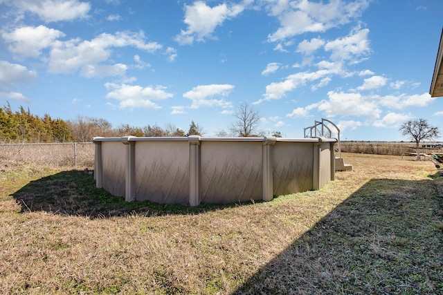 view of property exterior featuring a yard, stucco siding, fence, and an outdoor pool