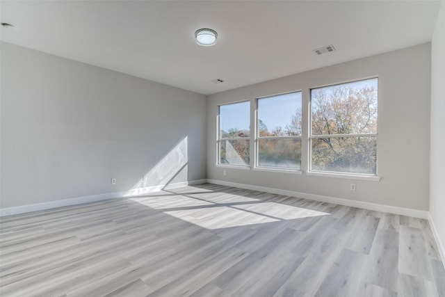 unfurnished room with a healthy amount of sunlight and light hardwood / wood-style flooring