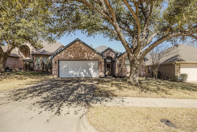 ranch-style home with brick siding, driveway, and an attached garage