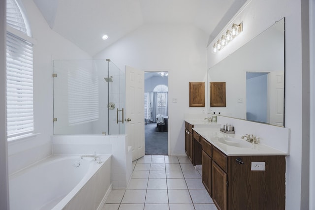 ensuite bathroom featuring double vanity, ensuite bath, vaulted ceiling, a shower stall, and a sink