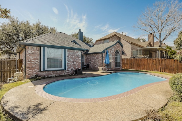 view of swimming pool featuring a patio, fence, and a fenced in pool