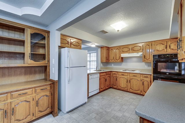 kitchen with white appliances, sink, and a textured ceiling