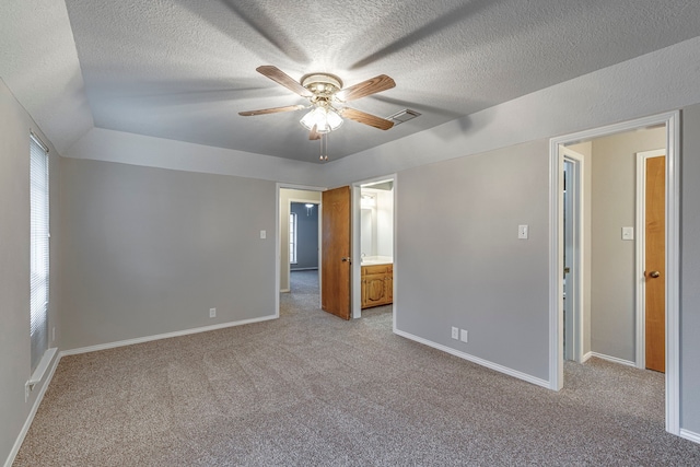 unfurnished bedroom featuring ceiling fan, light colored carpet, and a textured ceiling