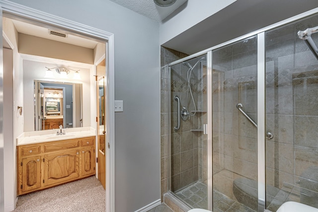 bathroom featuring a shower with door and vanity