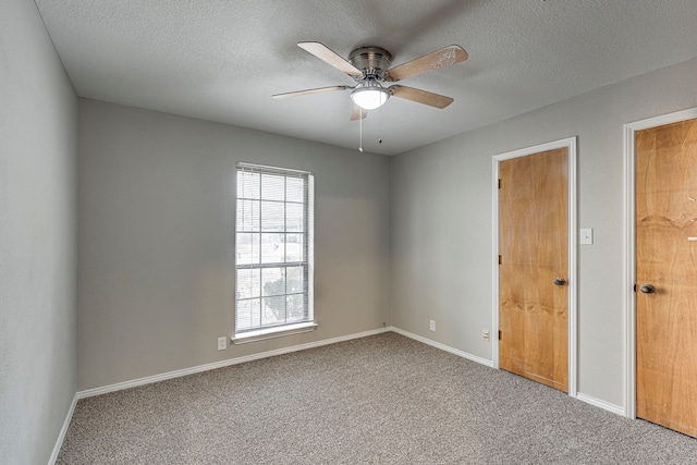 carpeted empty room featuring a textured ceiling and ceiling fan