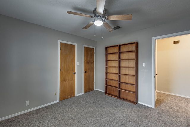 unfurnished bedroom featuring a textured ceiling, carpet floors, and ceiling fan