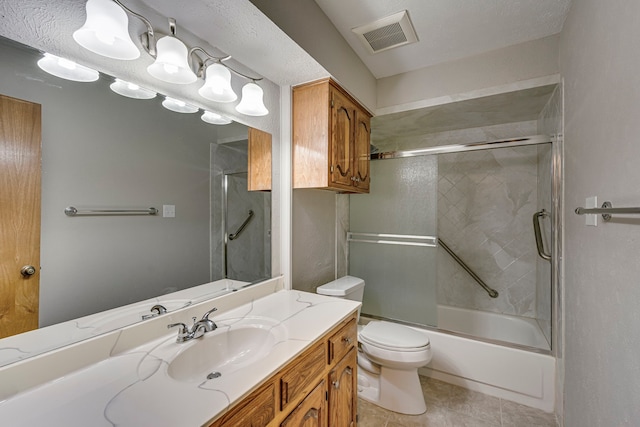 full bathroom featuring vanity, bath / shower combo with glass door, tile patterned floors, and toilet