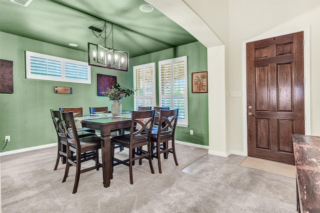 carpeted dining area with a chandelier, visible vents, and baseboards