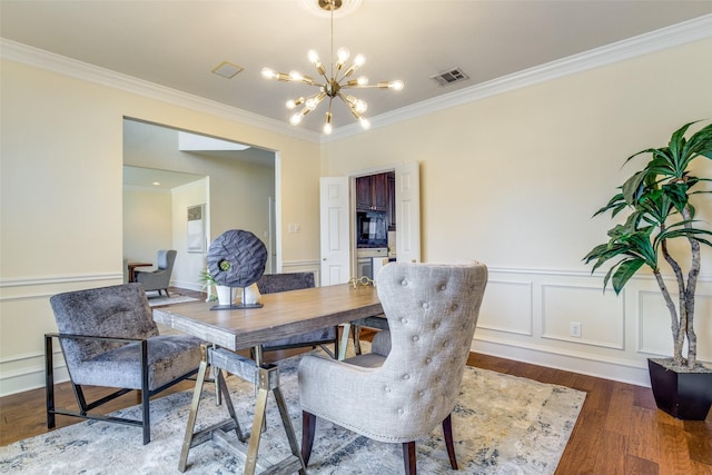 dining space with dark wood-type flooring, visible vents, ornamental molding, and an inviting chandelier