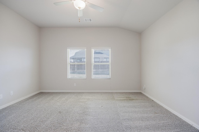 carpeted empty room featuring vaulted ceiling, a ceiling fan, visible vents, and baseboards