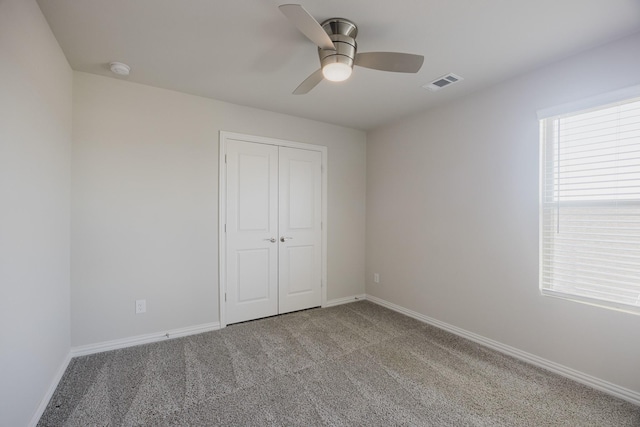 unfurnished bedroom featuring visible vents, baseboards, a closet, and carpet flooring