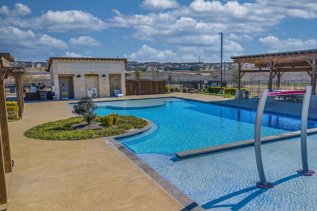 community pool with a patio area and fence