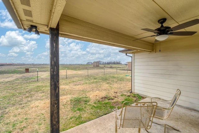 view of yard with a rural view, a patio area, and ceiling fan