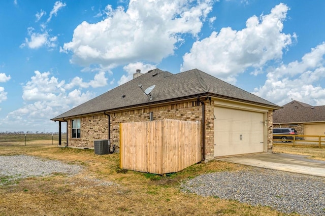 view of home's exterior with a garage and central AC