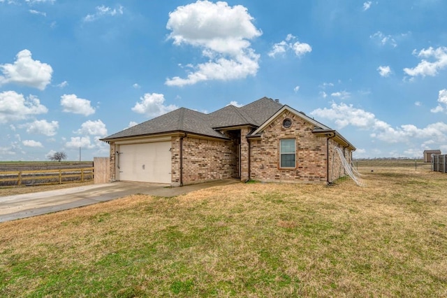 view of front of property with a garage, a front lawn, and a rural view