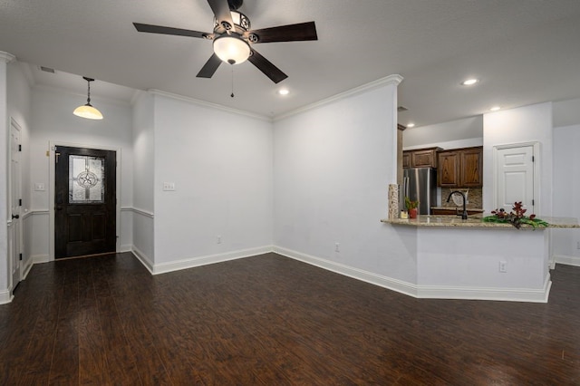 unfurnished living room with ornamental molding, dark hardwood / wood-style floors, and ceiling fan