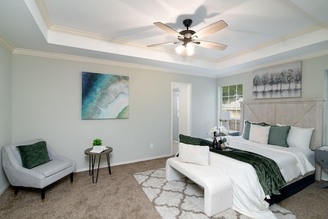 bedroom with ornamental molding, carpet floors, ceiling fan, and a tray ceiling