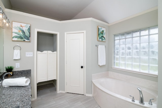 bathroom with vaulted ceiling, ornamental molding, sink, and a washtub