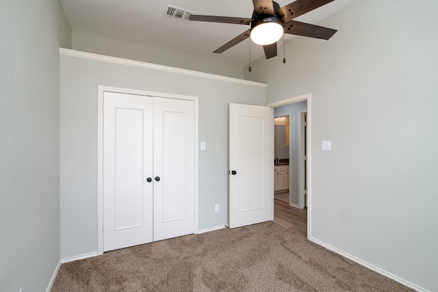 unfurnished bedroom featuring a closet, ceiling fan, and carpet