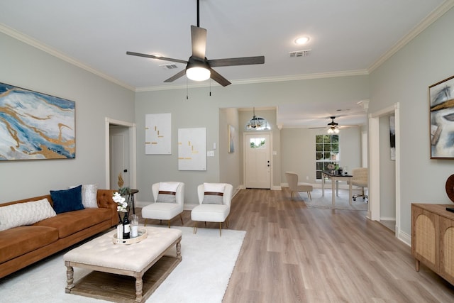 living room with crown molding, light hardwood / wood-style floors, and ceiling fan